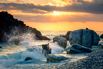 Stormy Sea waves splash up to the sky with sun. Sunset at Sea. Storm. Seascape.