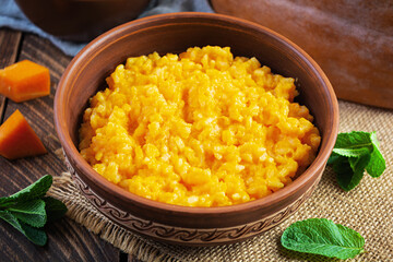 Delicious homemade pumpkin porridge on wooden background. Healthy vegan food