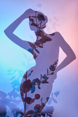 Beauty flowers body of woman with double exposure. Portrait of a girl neon light and color, professional makeup, nude back and chest of woman, flowers inside