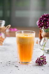 Side view on glass of fresh orange juice on a light background