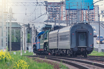 Obraz premium Retro steam train on city background. Moscow.