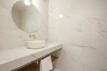 sink in marble bathroom with golden faucet and towel