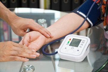 Doctor checking old female patient arterial blood pressure. Health care.Monitoring blood pressure of patients using upper arm blood pressure monitor in the