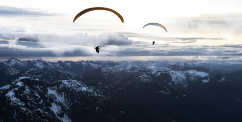 Adventure Composite Image of Paraglider Flying up high in the Rocky Mountains. Sunny Sunset Sky. Aerial Background from British Columbia, Canada. Extreme Sport Concept. Panorama