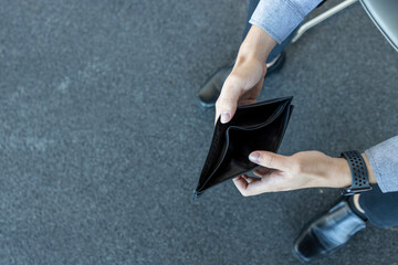 closeup empty wallet (no money) in the hands of an man with soft-focus and over light in the background