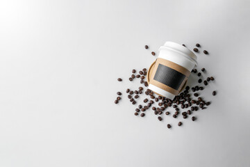 paper cup of coffee and beans on white table background. top view. space for text