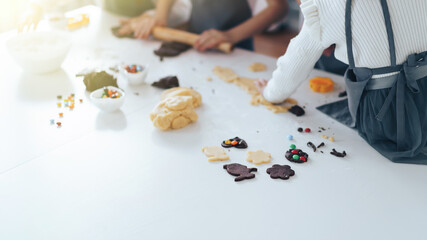 Children prepare cookies with sweets, a boy rolls out the dough with a rolling pin. Leisure activity with children concept