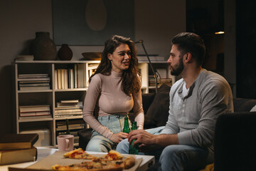couple enjoying evening together eating pizza at home