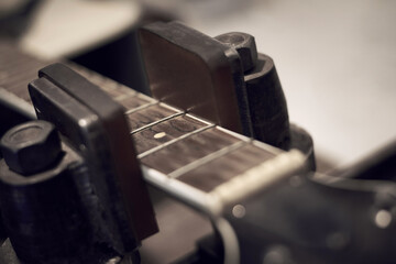 Guitar with removed strings being repaired at a service center.