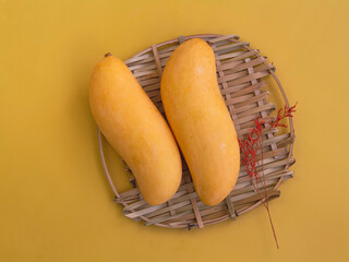 Two Thai Mangoes with yellow peel and dried flower