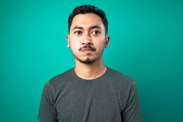 Obraz premium Portrait of thinking and confused young man on green background