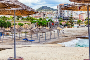Empty beach with reed beach umbrellas, nobody on the beach. Beach with no travellers and tourists. Cancellations due to coronavirus covid-19. Quarantine.