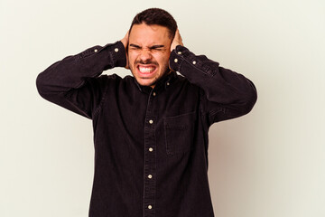Obraz premium Young caucasian man isolated on white background covering ears with hands.