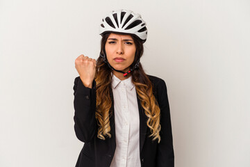 Young mexican woman riding a bicycle to work isolated on white background showing fist to camera, aggressive facial expression.