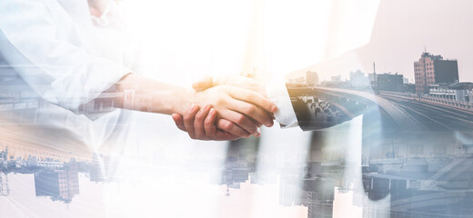 Double exposure businessman and businesswoman shake hands with city backgrounds, agree to work...