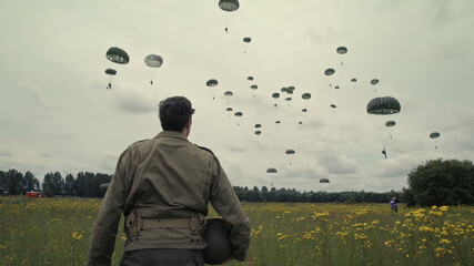 Soldier looks at paratroopers in Normandy