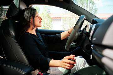young latin woman driving luxury car