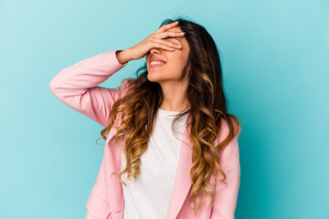 Young mexican woman isolated on blue background covers eyes with hands, smiles broadly waiting for a surprise.