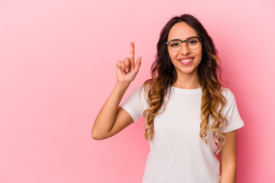 Young mexican woman isolated on pink background showing number one with finger.