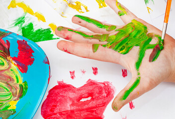 child painting on hand and mixing colors