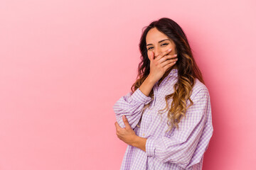 Young mexican woman isolated on pink background laughing happy, carefree, natural emotion.