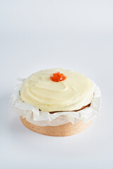 Sweet baked mini carrot cake with cream cheese frosting on recycle Mini Wooden Baking Mold, white background, copy space, selective focus.