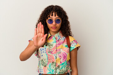 Young mixed race woman wearing sunglasses taking a vacation isolated standing with outstretched hand showing stop sign, preventing you.