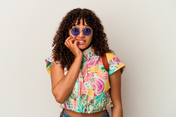 Young mixed race woman wearing sunglasses taking a vacation isolated biting fingernails, nervous and very anxious.