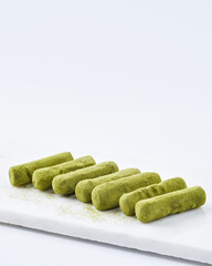Japanese matcha green tea truffles on a marble cutting board, white background, copy space. Selective focus. Japanese dessert.
