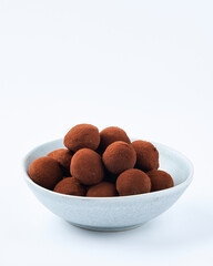 Chocolate truffles on a marble cutting board, white background, copy space. Selective focus, dessert concept. Close up.