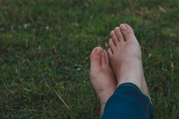 bare feet on grass, dramatic dark tone.
