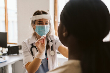 Female medical expert doing patient's medical test during COVID-19