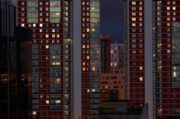Fototapeta na wymiar Building windows at night. Abstract urban skyscraper