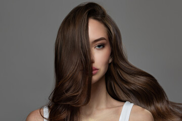 Woman wavy hair. Portrait on a dark gray background