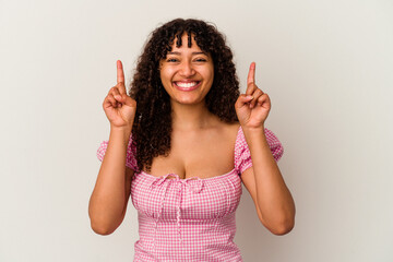 Young mixed race woman isolated on white background indicates with both fore fingers up showing a...