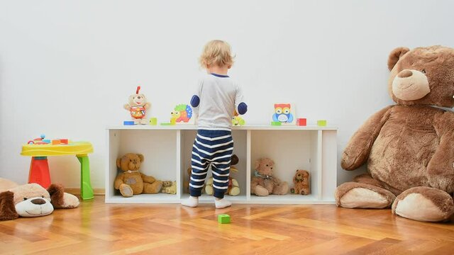 Happy cute child boy having fun playing with colorful wooden toys, at home. Indoor activity for kids