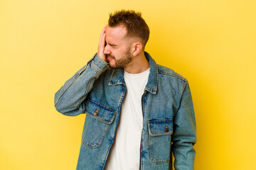 Young tattooed caucasian man isolated on yellow background having a head ache, touching front of the face.