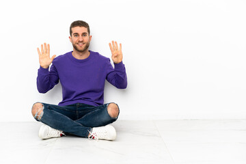 Young man sitting on the floor counting nine with fingers