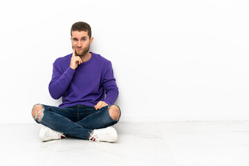 Young man sitting on the floor and thinking