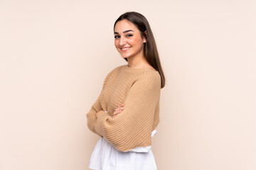 Obraz premium Young caucasian woman isolated on beige background with arms crossed and looking forward