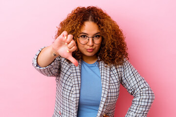 Young latin curvy woman isolated on pink background showing thumb down, disappointment concept.