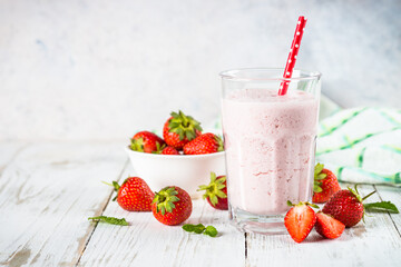 Strawberry smoothie or milkshake at white kkitchen table.