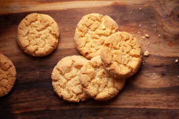 Close-up of delicious freshly baked simple cookies or biscuits. Isolated over a wooden top  background.