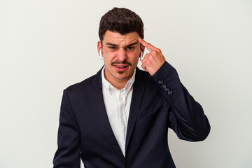 Young business caucasian man wearing wireless headphones isolated on white background showing a disappointment gesture with forefinger.