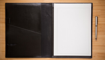 Notepad with open black cover. copybook on the wooden table. Notebook.