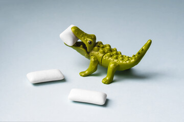 Naklejka premium Green Toy crocodile eats chewing gum pads.