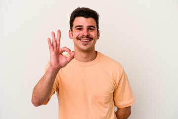 Young caucasian man isolated on white background cheerful and confident showing ok gesture.