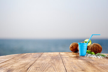 Summer drink on a wooden table on the shore of the ocean on a beautiful sunny day 