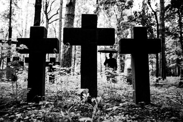 A man mourns a dead man on a grave in a cemetery. Mourning and mourning for the dead. War Memorial.