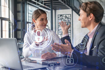 Businessman and businesswoman working together to protect clients confidential information and cyber security. IT hologram padlock icons over office background with panoramic windows.